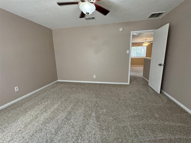 spare room with ceiling fan, a textured ceiling, and carpet flooring