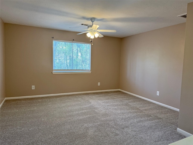 carpeted empty room with ceiling fan and a textured ceiling