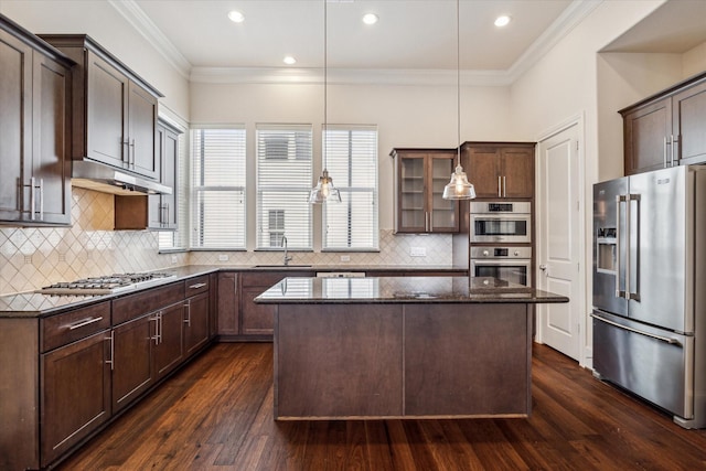 kitchen with stainless steel appliances, a kitchen island, dark brown cabinets, and pendant lighting