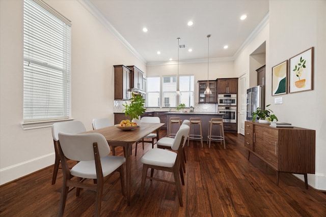 dining area with ornamental molding and dark hardwood / wood-style flooring