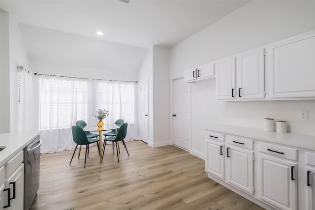 dining space featuring vaulted ceiling and light wood-type flooring