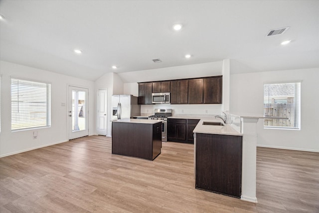 14231 Walworth Creek Ct, Rosharon, TX 77583 - kitchen featuring appliances with stainless steel finishes, a sink, a kitchen island, light countertops, and dark brown cabinetry