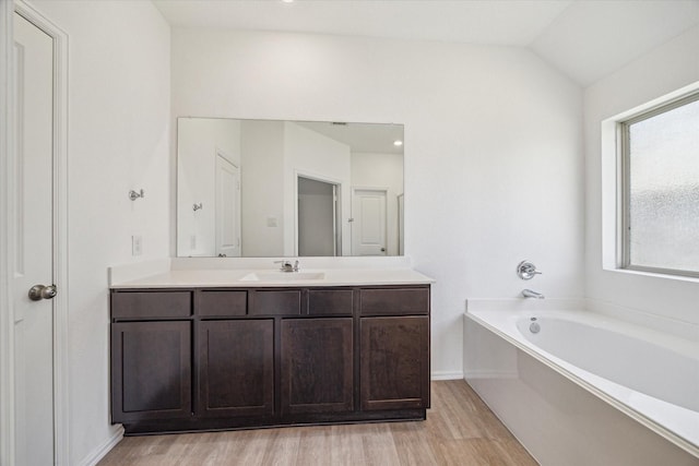 14231 Walworth Creek Ct, Rosharon, TX 77583 - full bathroom featuring wood finished floors, vanity, a garden tub, baseboards, and vaulted ceiling