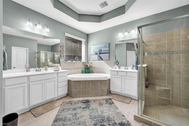 bathroom featuring vanity, a tray ceiling, separate shower and tub, and tile patterned flooring