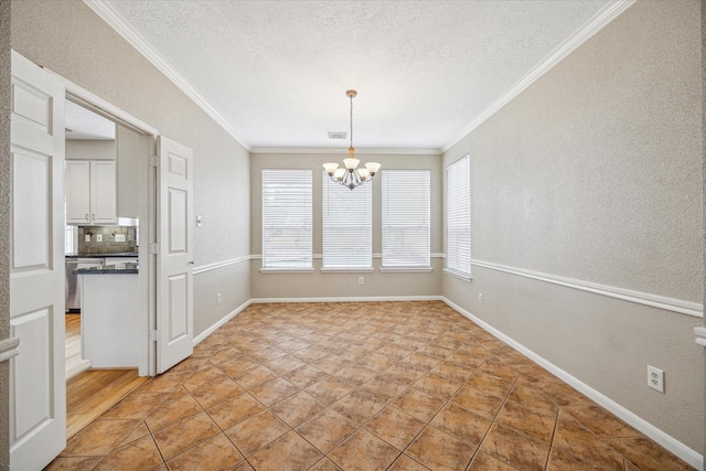 unfurnished dining area with crown molding, visible vents, a textured ceiling, a chandelier, and baseboards