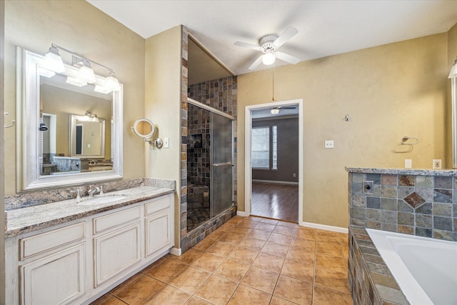 bathroom with a relaxing tiled tub, ceiling fan, tile patterned floors, vanity, and a shower stall