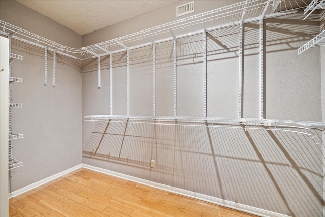 walk in closet featuring visible vents and wood finished floors