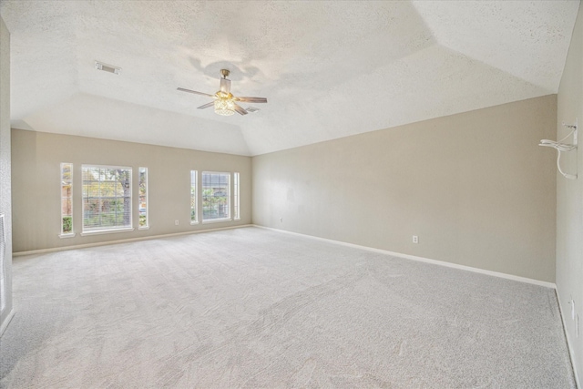 carpeted empty room with visible vents, baseboards, a ceiling fan, lofted ceiling, and a textured ceiling