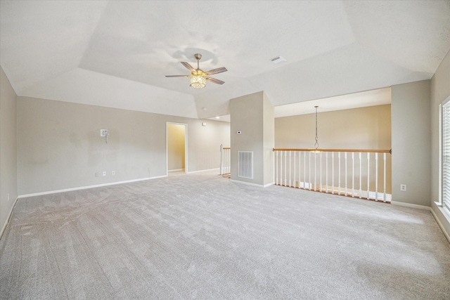 spare room featuring lofted ceiling, baseboards, visible vents, and a ceiling fan