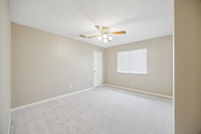 spare room with baseboards, visible vents, a ceiling fan, and carpet flooring