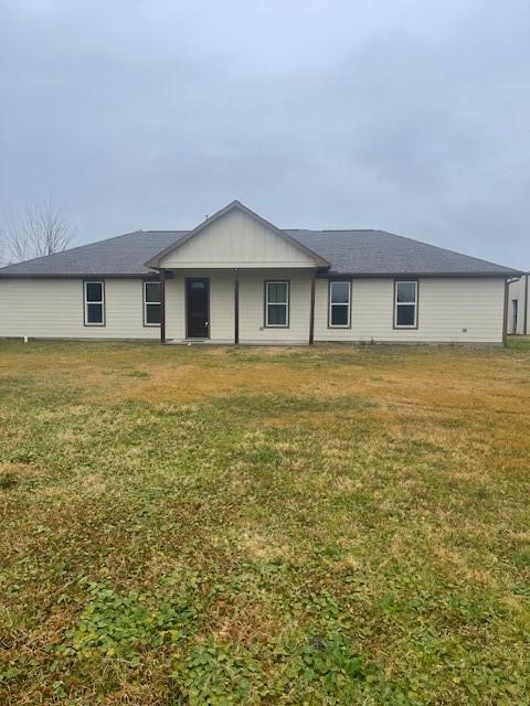 back of house featuring a lawn