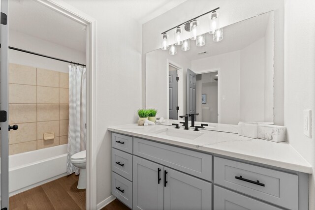 full bathroom with shower / tub combo with curtain, wood-type flooring, toilet, and vanity