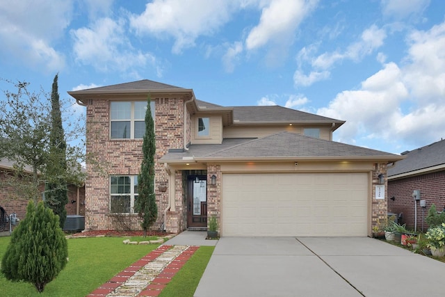 prairie-style home with a garage, central AC unit, and a front lawn