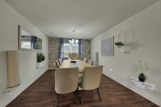 dining area with an inviting chandelier and dark wood-type flooring