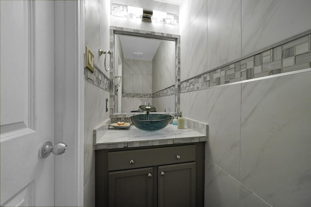 bathroom featuring vanity and tile walls