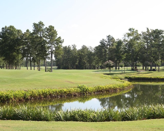 surrounding community featuring a water view and a lawn