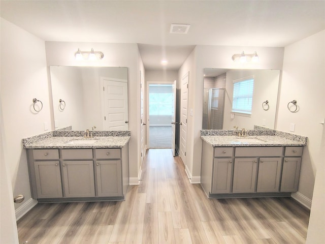 bathroom featuring an enclosed shower, hardwood / wood-style floors, and a wealth of natural light