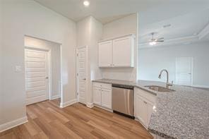 kitchen featuring sink, ceiling fan, dishwasher, white cabinets, and light wood-type flooring