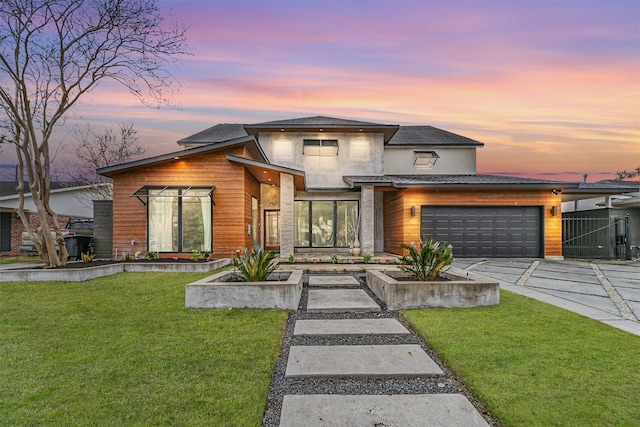 modern home featuring a garage and a lawn