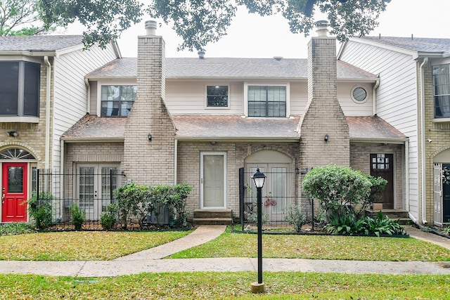 townhome / multi-family property featuring a front lawn