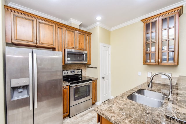 kitchen with sink, light stone counters, ornamental molding, stainless steel appliances, and backsplash