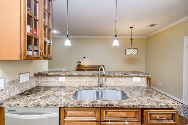 kitchen with light stone counters, sink, and decorative light fixtures