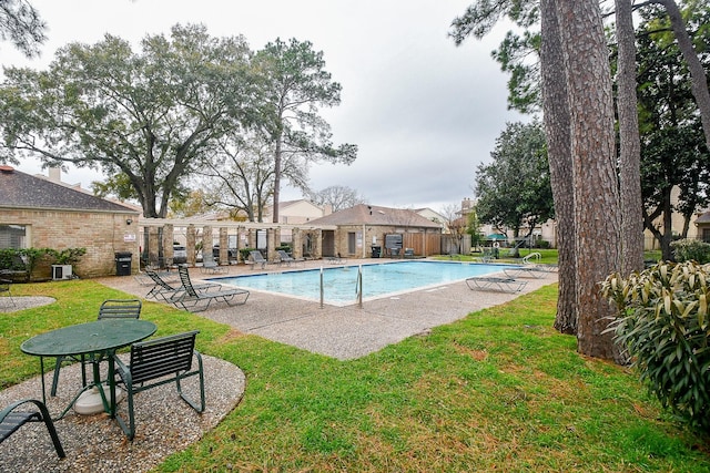 view of swimming pool featuring a yard, a patio, and central air condition unit