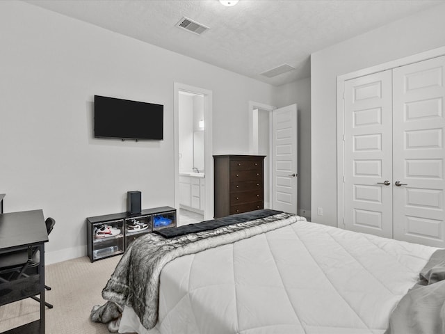 carpeted bedroom featuring connected bathroom, a closet, and a textured ceiling