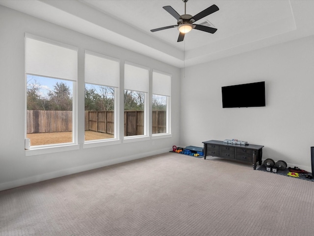 game room featuring a raised ceiling, ceiling fan, and carpet