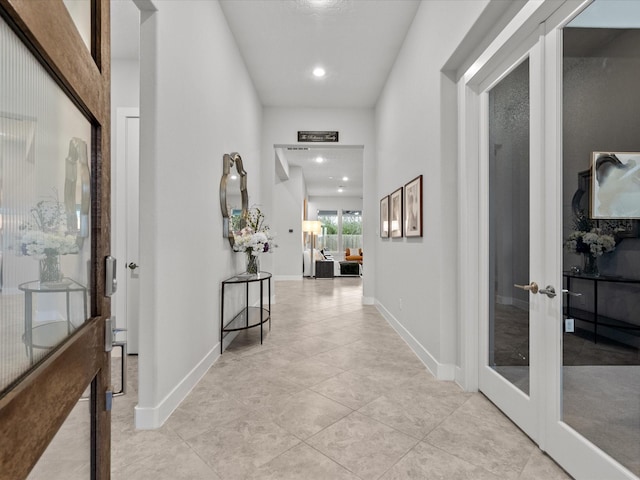 corridor featuring french doors and light tile patterned floors