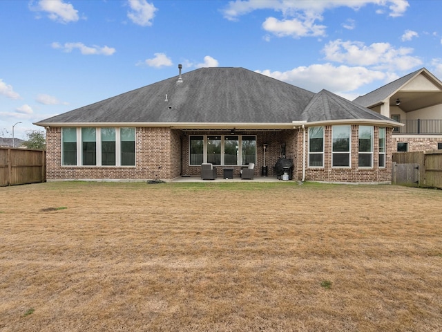 rear view of property featuring a patio and a lawn