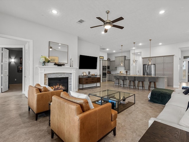 living room with sink, a fireplace, and ceiling fan