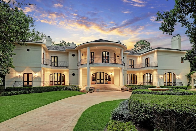 exterior space featuring a yard, french doors, and a balcony