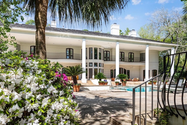 rear view of property featuring a balcony and a patio area