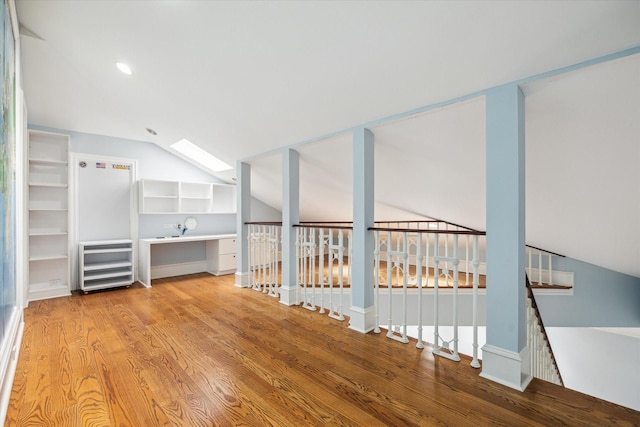 interior space with lofted ceiling with skylight and light hardwood / wood-style floors