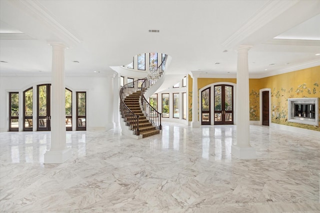 interior space featuring french doors, ornamental molding, a healthy amount of sunlight, and decorative columns