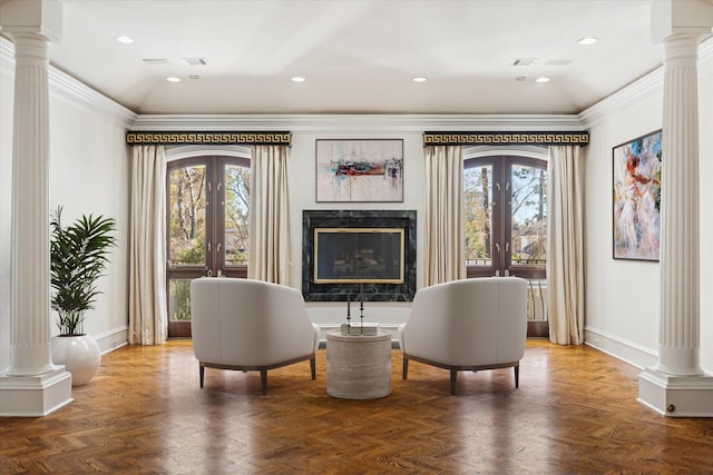 sitting room with parquet floors, plenty of natural light, decorative columns, and french doors