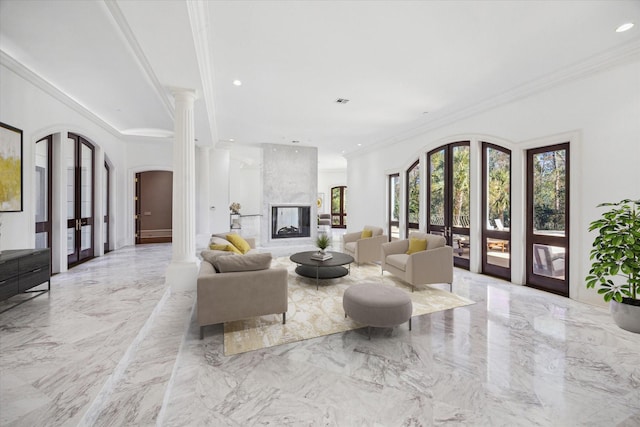 living room with decorative columns, a multi sided fireplace, ornamental molding, and french doors