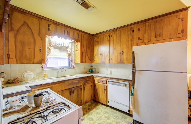 kitchen with sink, tile countertops, and white appliances