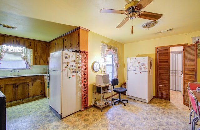 kitchen with white refrigerator, ceiling fan, sink, and decorative backsplash