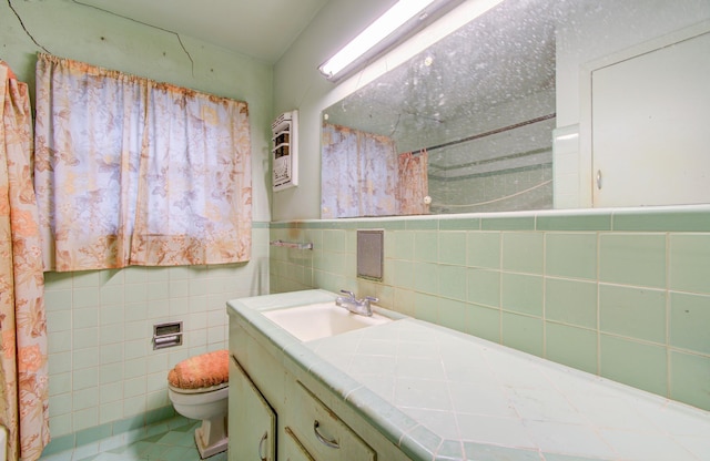 bathroom featuring vanity, tile walls, tile patterned floors, and toilet