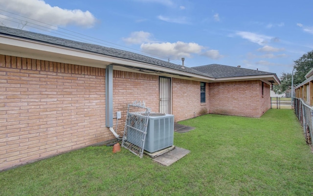 back of house featuring central AC and a lawn