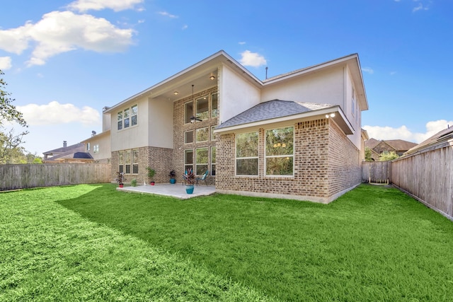 rear view of house featuring a yard and a patio area