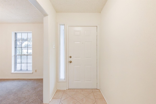 entryway featuring a textured ceiling and light tile patterned flooring