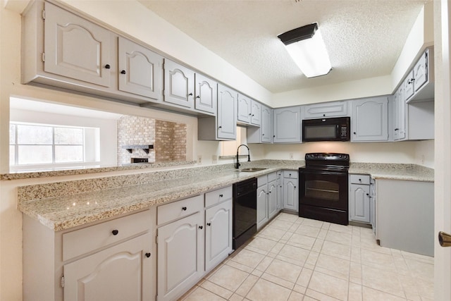 kitchen featuring sink, gray cabinetry, a textured ceiling, light stone countertops, and black appliances