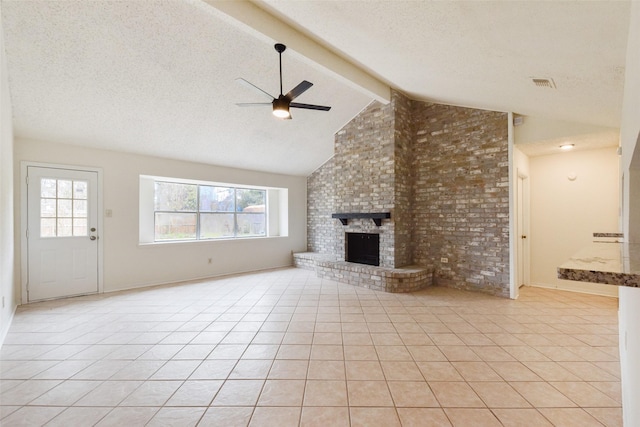 unfurnished living room with vaulted ceiling with beams, light tile patterned floors, ceiling fan, a brick fireplace, and a textured ceiling