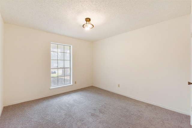 carpeted empty room featuring a textured ceiling