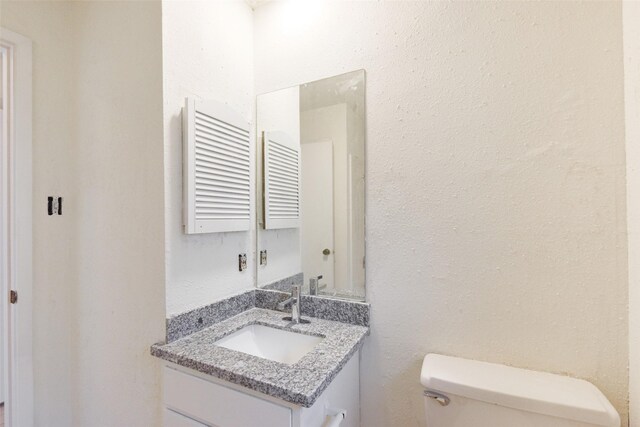 bathroom with vanity, radiator heating unit, and toilet