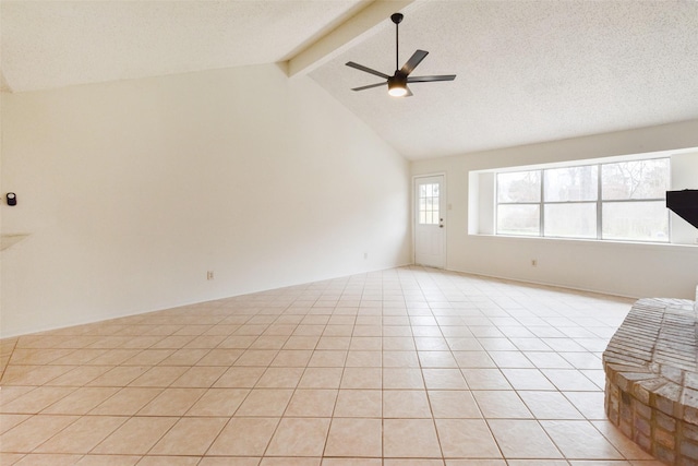 tiled spare room with lofted ceiling with beams, ceiling fan, and a textured ceiling