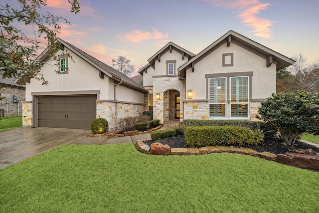 view of front of property with a garage and a lawn